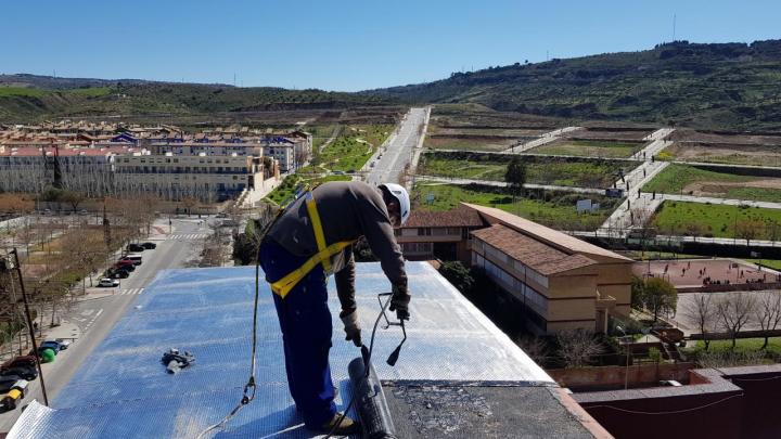 Un operario trabaja en la impermeabilización de cubiertas en Granada Un operario trabaja en la impermeabilización de cubiertas en Granada